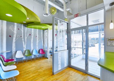 A bright, colorful pediatric dental clinic waiting room with playful decor and kid-friendly seating.